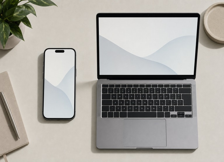 A smartphone and laptop side by side on a desk, representing the choice between mobile and desktop play at an online casino.